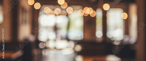 Blurred cafe interior with warm lighting, wooden textures, and soft focus. Modern seating area and decorative elements, suitable for lifestyle and creative backgrounds.