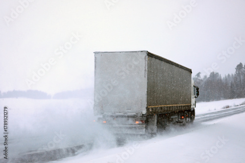 Semi Truck Driving on Snowy Road. Challenging Driving Conditions. 