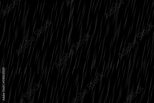 Heavy rainfall in diagonal motion falling down on dark black background, abstract monsoon rain overlay effect for video or photography