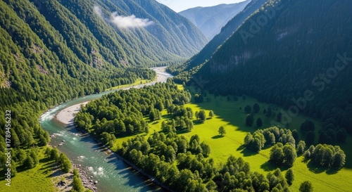Aerial view of a river flowing through a lush green mountain valley