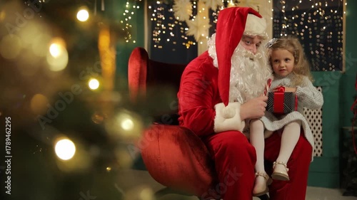 Child sitting on Santas lap surrounded by warm bokeh lights and festive sparkle