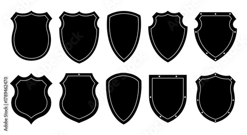 Collection of ten different black shield shapes with textured edges on white background