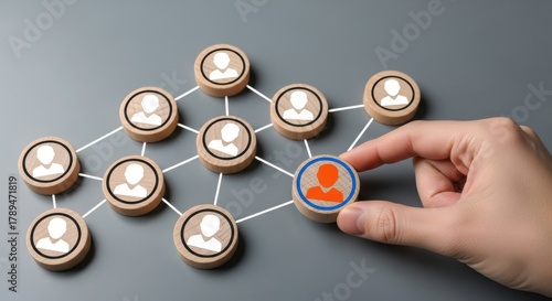 Hand connecting wooden figures in a network, team building concept