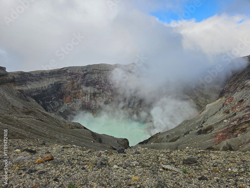 Unique landscape of the crater of Nakadake in Mount Aso Japan with rock and mountain background