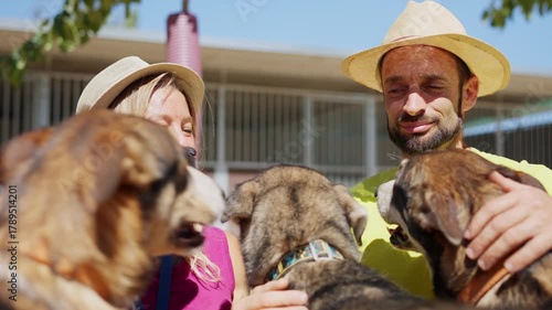 Animal caretakers smile with happy dogs getting kisses from the animals