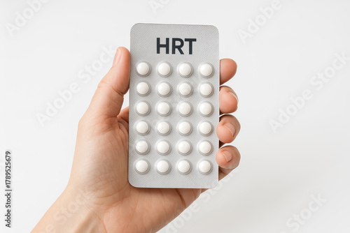 Close up of hand holding HRT pill blister pack for menopause treatment, showcasing health and wellness. This emphasizes importance of hormone replacement therapy