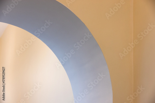 A smooth blue arc sweeps across a warm beige wall, creating a calm backdrop