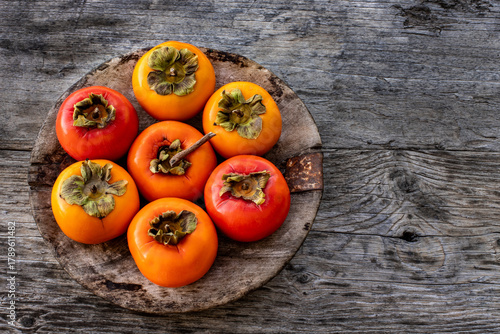Ripe persimmon fruits in the wooden bowl. Trabzon or cennet hurması 
