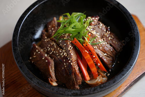 Savory korean bulgogi beef bowl with fresh green onions and red peppers