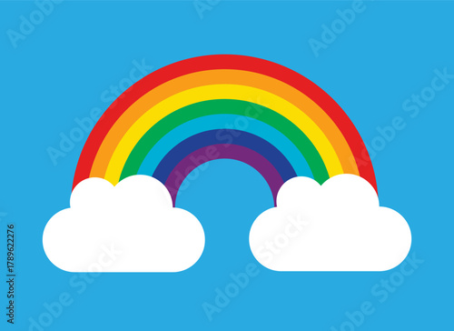 Vibrant rainbow arching over fluffy white clouds on a blue sky