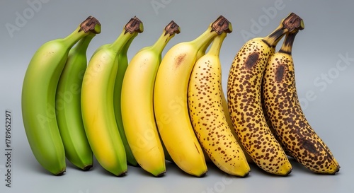 Row of bananas showing ripening stages from green to brown spots