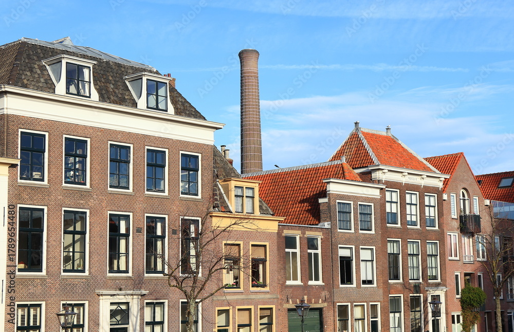 Fototapeta premium Oude Vest Building Facades with Power Station Chimney in the Background in Leiden, Netherlands