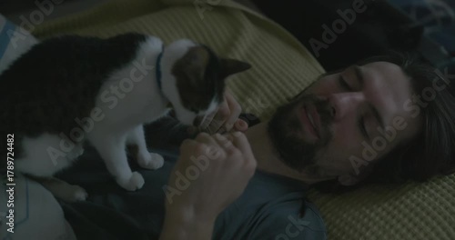Man Waking up in Bed with Smartphone and Kitten. 4K 10-bit