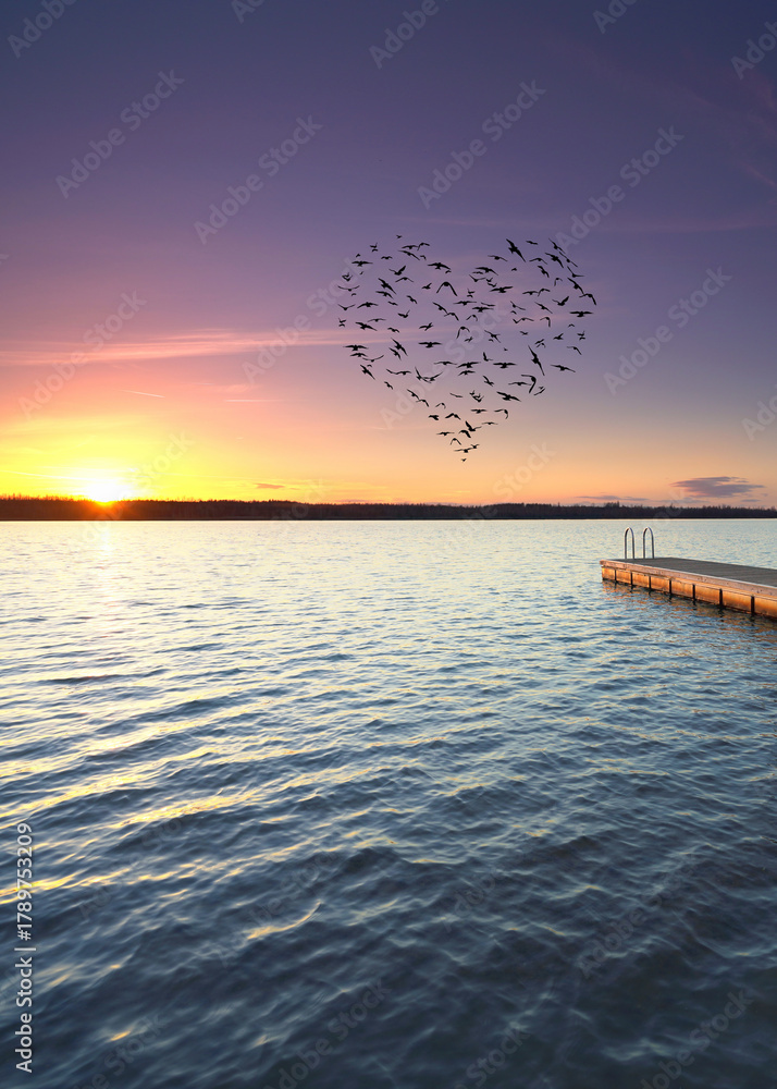 Fototapeta premium lovely sunset over the wooden pier with heart shaped birds