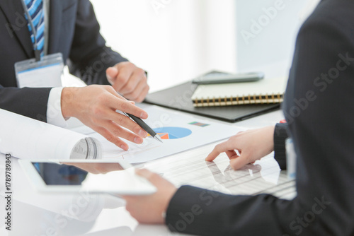 資料を見せて打ち合わせをするビジネスマンとビジネスウーマン 