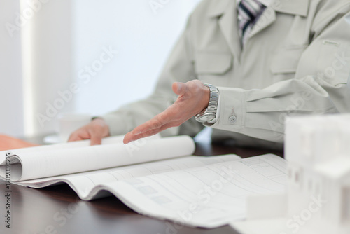 打ち合わせをする作業着姿の男性