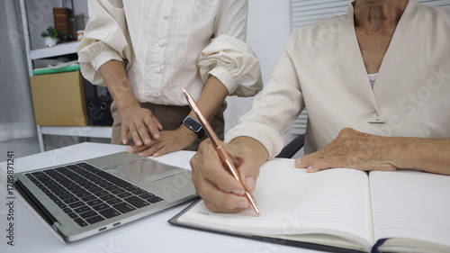 businessman hands searching for data on Notebook with analyzing charts at his workplace.