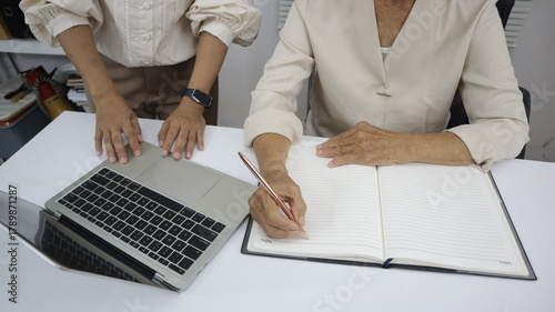 businessman hands searching for data on Notebook with analyzing charts at his workplace.