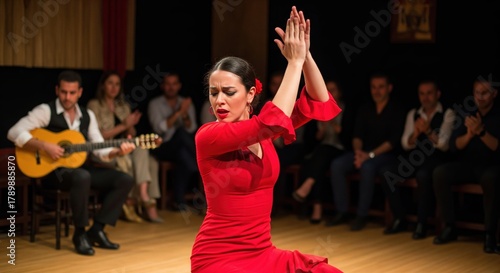 Passionate flamenco dancer in red dress clapping hands on stage with guitarist and live audience
