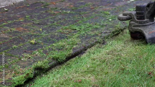 Close-up of man trims grass along curb with cordless hand-held lawn trimmer with line. High quality 4k footage
