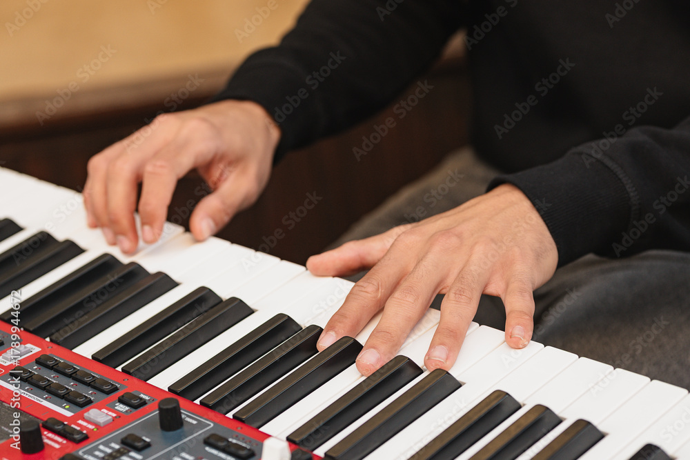 Obraz premium Musician plays keyboard in studio setting showcasing skillful hand movement during practice session