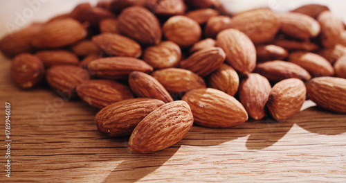 Space, nuts and almonds on table for diet, vegan meal and healthy snack for nutrition. Background, food production and roasted seeds on wooden board for organic benefits, natural vitamins and protein