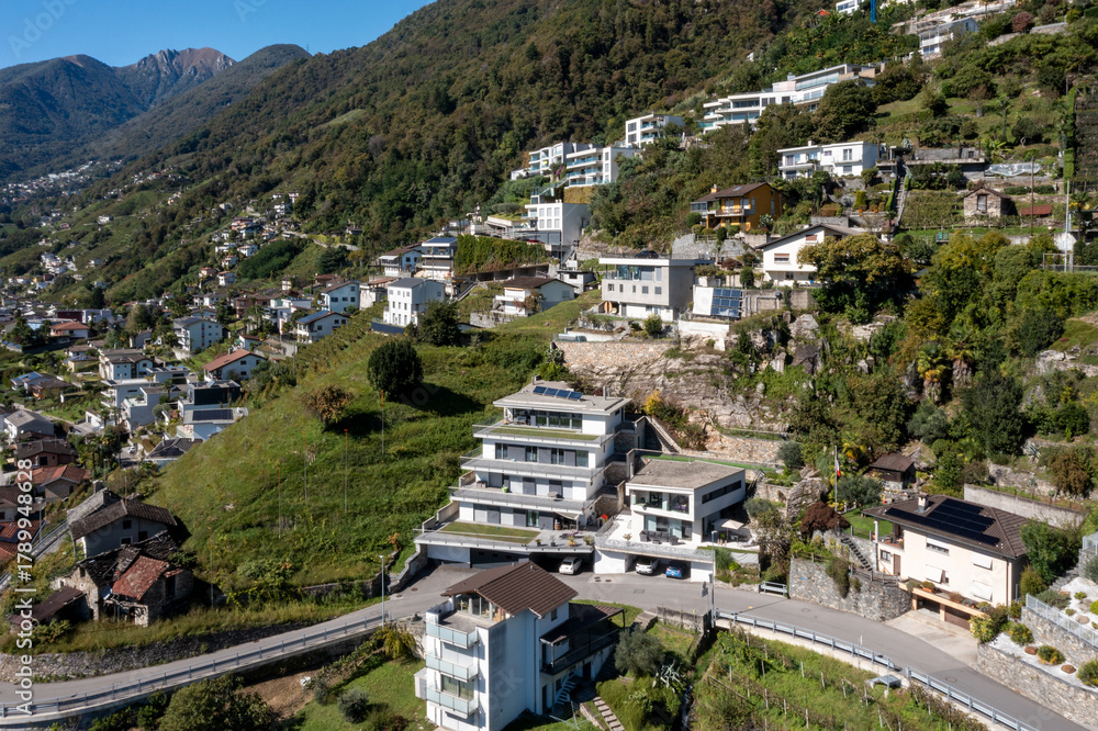 Naklejka premium Aerial view of a group of houses in Switzerland in a mountainous part of the south of the country