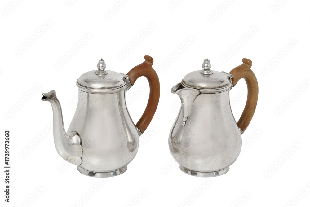 Fototapeta premium Two antique silver coffee pots with wooden handles on white background teapot creamer