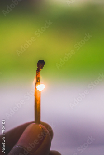 hand holding a lit match
