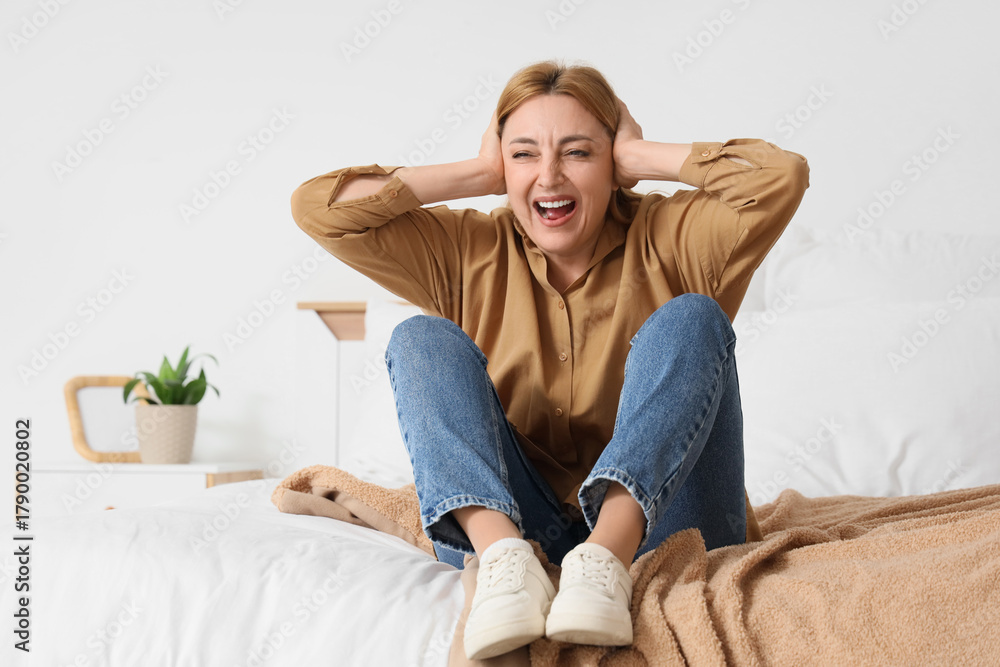 Obraz premium Screaming mature woman sitting in bedroom