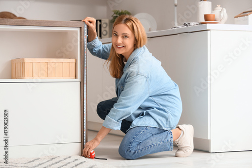Mature woman measuring tabl...