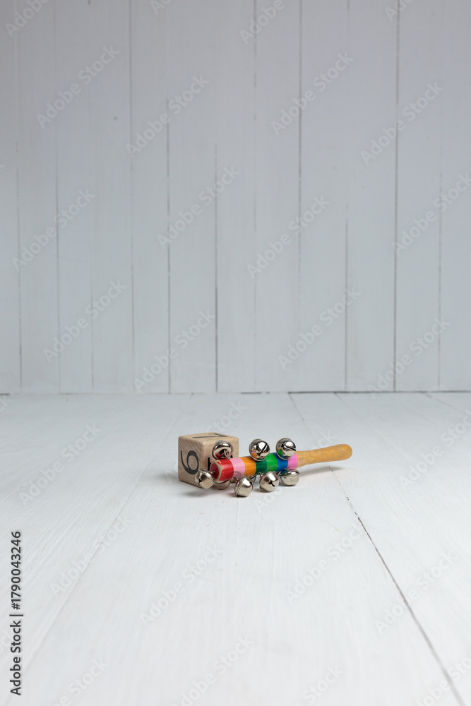 Obraz premium Wooden Baby Rattle and Block on a White Wooden Floor