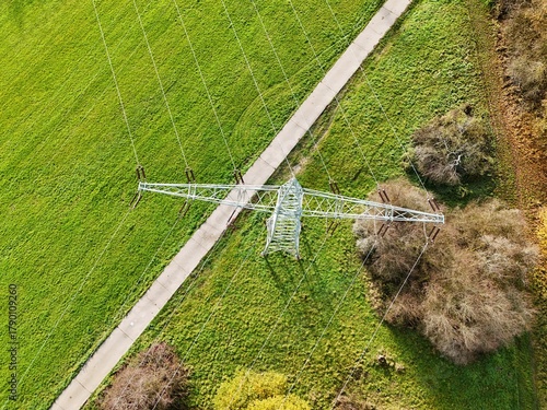 Aerial View of High Voltage Power Line Tower in Green Landscape