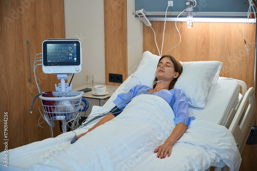 Woman receiving intravenous therapy while resting in hospital bed