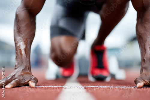Sprinter crouched at starting blocks ready to race
