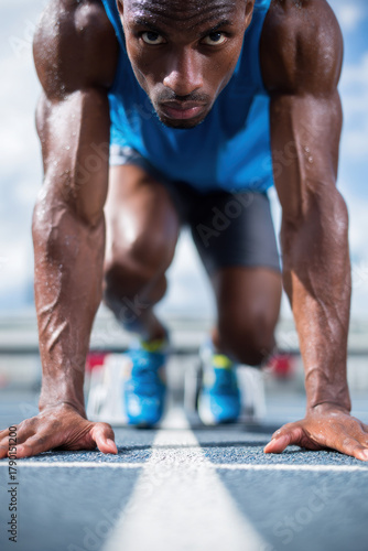 Sprinter crouched at starting blocks ready to race
