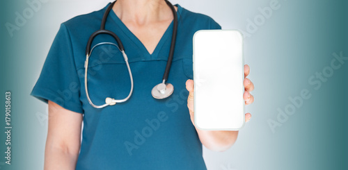 An indistinguishable woman doctor with a stethoscope, holding a modern smartphone with a blank screen in close-up.Copy space.