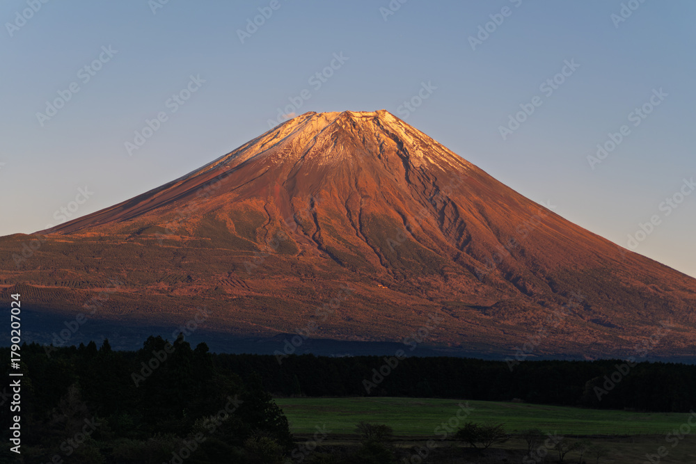 Obraz premium 黄金色の夕焼けに染まり雪化粧が輝く富士山