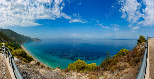 Fototapeta Naklejka Na Ścianę i Meble -  Scenic cliffs near sunny sea shore on a bright clear blue day in Greece. Pefkoulia beach with turquoise water and clear blue sky, Lefkada island, Ionian sea coast