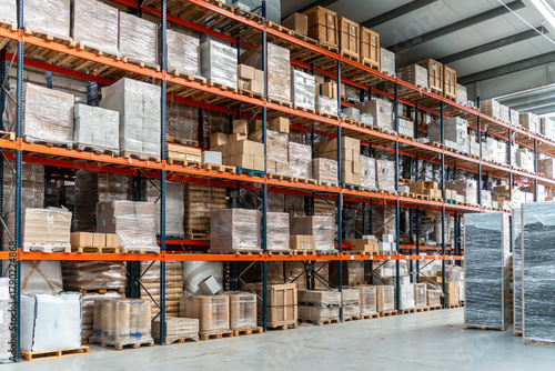 Foto Commercial logistics warehouse storing goods on tall racks