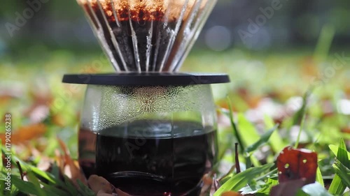Drip coffee on the autumn morning grass
