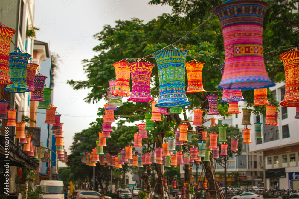 Fototapeta premium colorful paper lanterns hanging over a street in Vietnam, festive and vibrant atmosphere