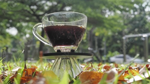 Drip coffee on the autumn morning grass