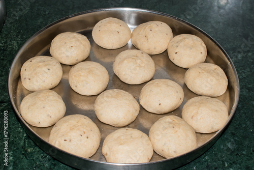 A plate full of sattu-stuffed dough balls ready to be cooked for making traditional Litti or bati. step or process of making litti