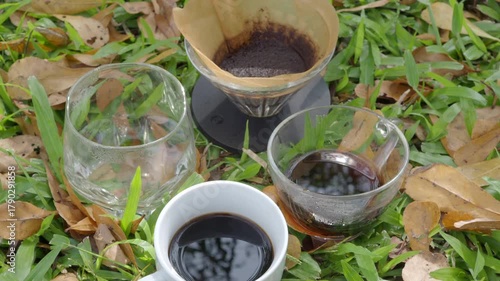 Drip coffee on the autumn morning grass
