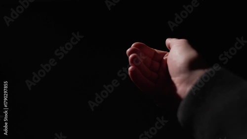 POV, close-up first person view stranger makes gesture of money with fingers on black background. Close-up of man's hands gesturing to suggest bribe. The man demands payment and returns the debt.