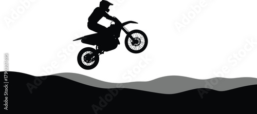 Silhouette of a motocross rider soaring through the air