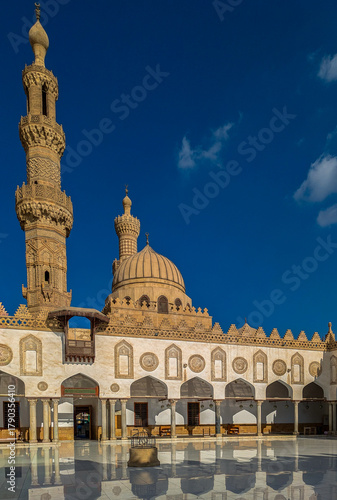 Al-Azhar Moschee Ägypten Innenhof der Al‑Azhar‑Moschee in Kairo zu sehen, mit ihren markanten Minaretten, der Kuppel und den Arkadengängen, die sich im hellen Marmorboden spiegeln.
