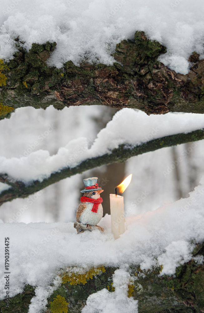 Naklejka premium winter landscape with candle and cute Christmas toy bird on snowy tree close up, nature background. fairy tale, mystery atmosphere. Christmas, New Year, Yule Holidays. witchcraft, magic ritual