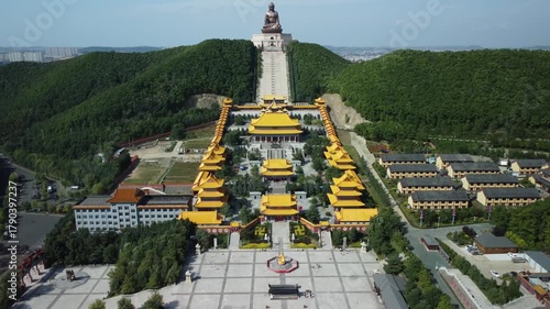 Aerial view of the Golden Buddha statue at Liudingshan Cultural Tourism Area in Dunhua City, Jilin Province, China. Massive golden statue overlooking Zhengjue Temple and facing the Changbai Mountain